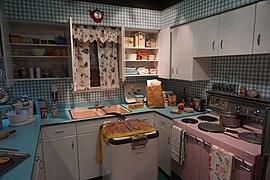 "Formica" countertops in "sea mist" light blue; profiled metal edges around laminate countertops; petal pink kitchen appliances