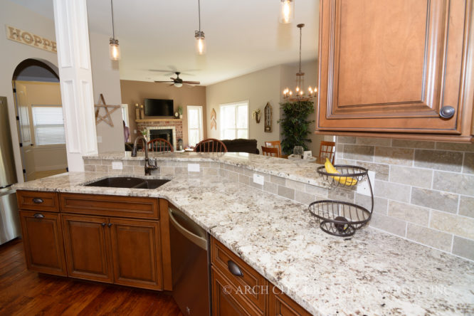 White granite color paired with medium maple cabinets and travertine back splash in missouri home